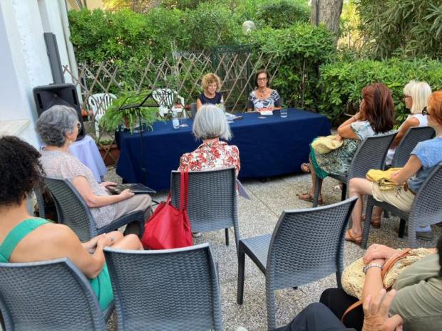 Conferenza: due donna al tavolo, pubblico di spalle