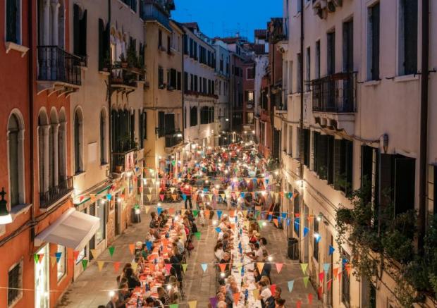 Due lunghe tavolate allestite in una strada di Venezia