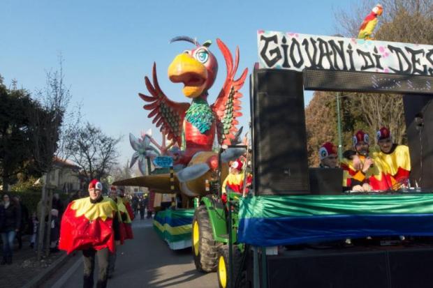 Sfilata di Carnevale con in primo piano un carro allegorico con un enorme pappagallo