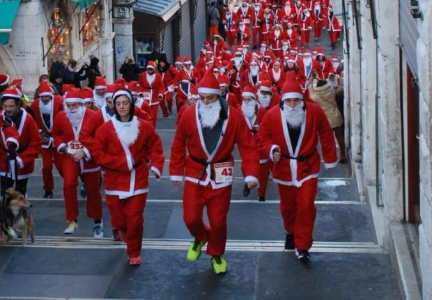 gruppo di podisti in costume da Babbo Natale percorre il ponte di Rialto