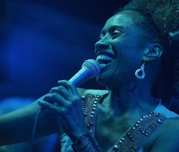 Primo piano di cantante che regge il microfono e sorride