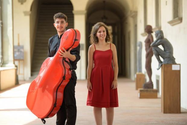 Duo formato da una ragazza e un ragazzo, che regge una custodia per viloncello