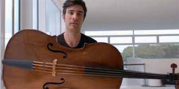 Violoncello in orizzontale e, dietro, un uomo