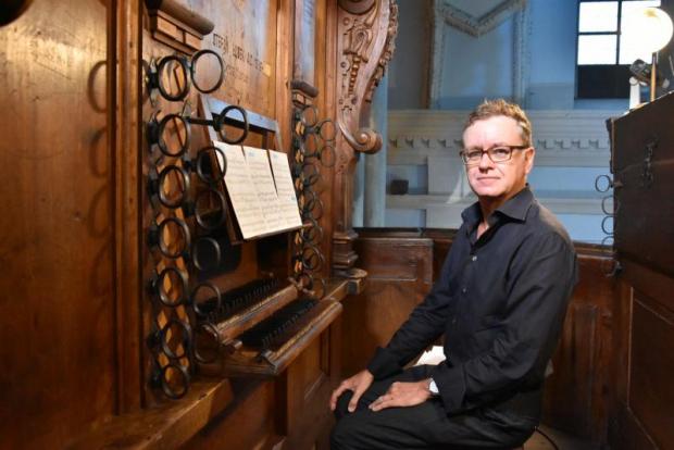 Organista in posa seduto all'organo