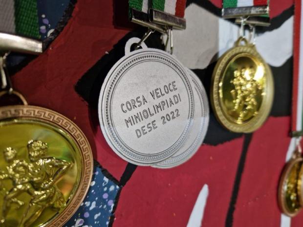 Tre medaglie per gare sportive: ai lati, due d'oro; al centro, una d'argento