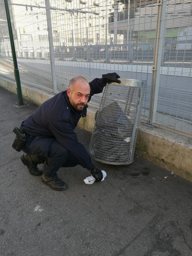 Agente della PM mostra dove ha trovato la droga sequestrata sotto il bidone delle immondizie