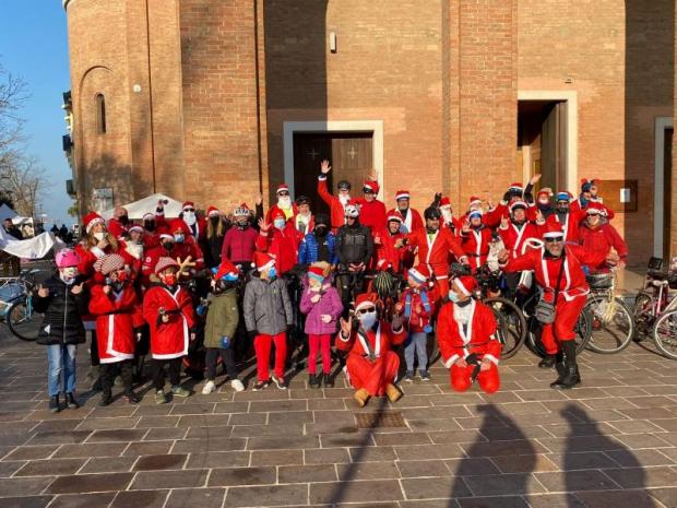 Gruppo di una quarantina di adulti e bambini in costume di Babbo Natale