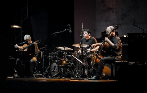 Un chitarrista, un batterista e un violoncellista sul palco