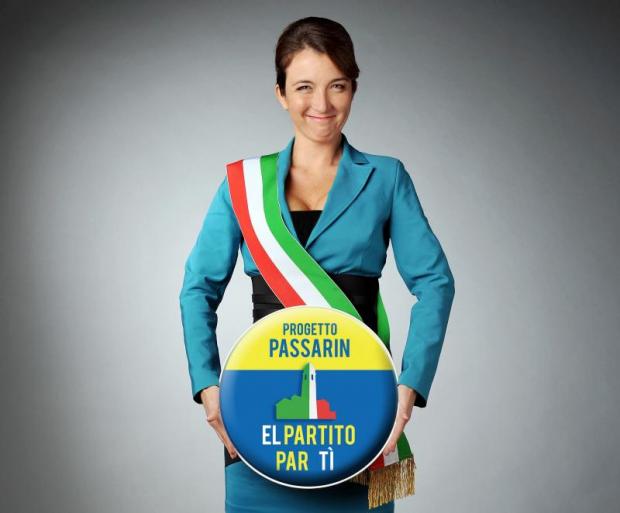 Donna in tailleur e fascia tricolore che regge il logo di un partito immaginario
