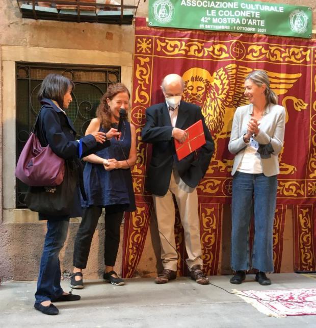 Quattro persone con la bandiera di San Marco come sfondo