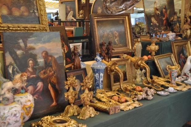 Merce d'antiquariato esposta sopra un banchetto: quadri, candelabri, vasi