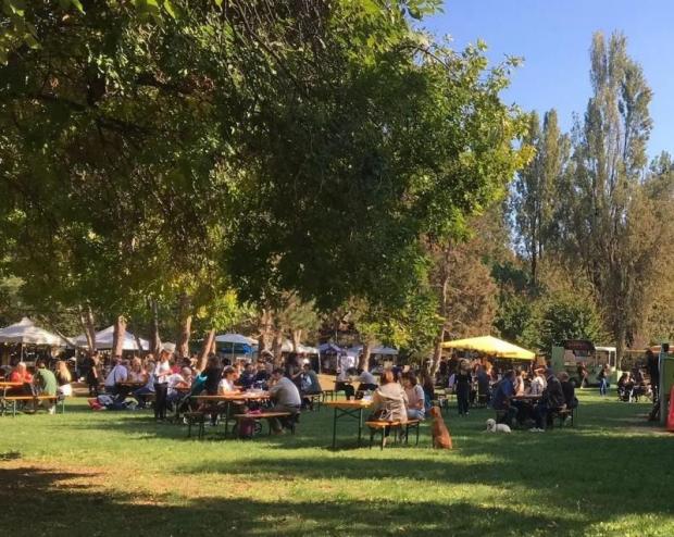 Persone sedute su tavoli sotto gazebo in un parco