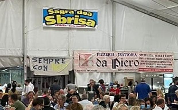 persone in un tendone da sagra, cartello "Sagra dea Sbrisa"