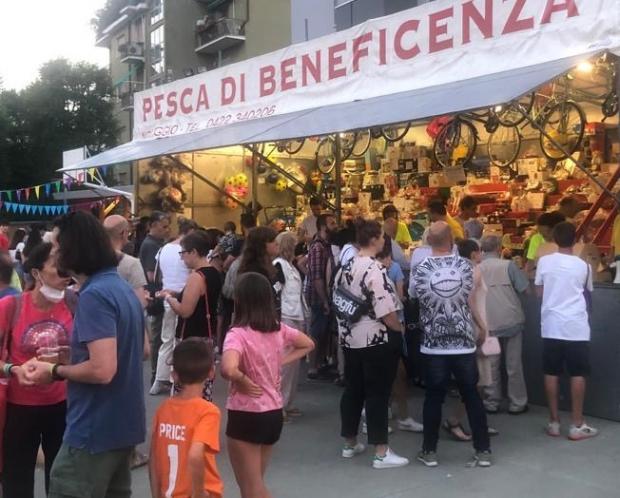 Folla di fronte al baracchino della pesca di beneficenza di una sagra paesana