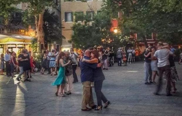 Varie coppie ballano il tango un un campo veneziano