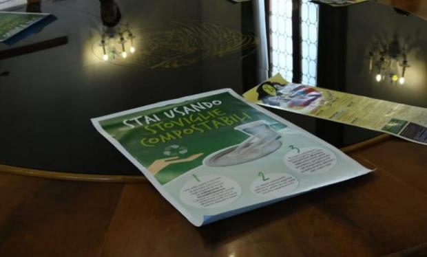 tavolo con manifesto su stoviglie compostabili