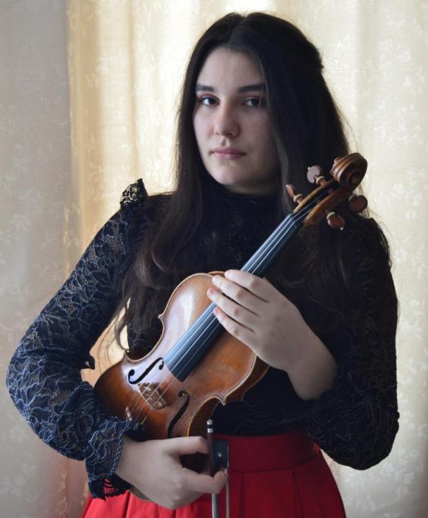 Una giovane violinista tiene in braccio il suo strumento