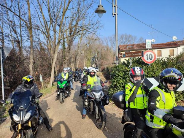 Gruppo di motociclisti transita su una strada di campagna