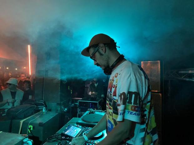 Dj con cappellino con frontino e occhiali da sole ai piatti