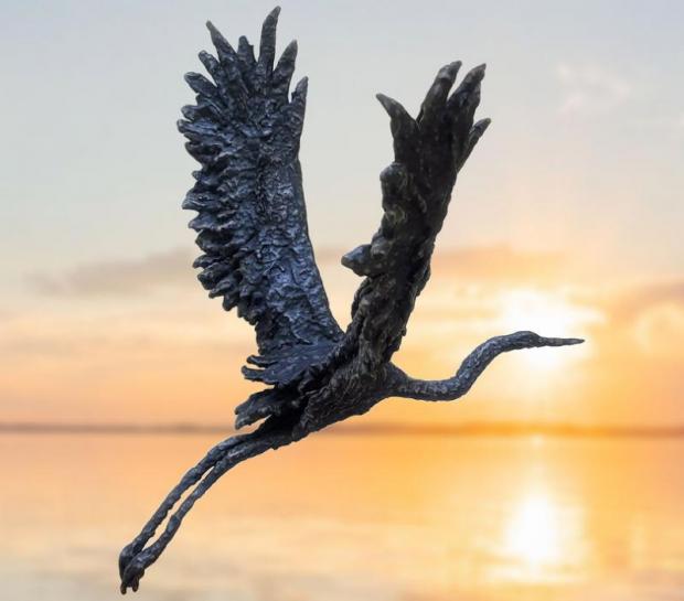 statua in bronzo di un airone su sfondo della laguna
