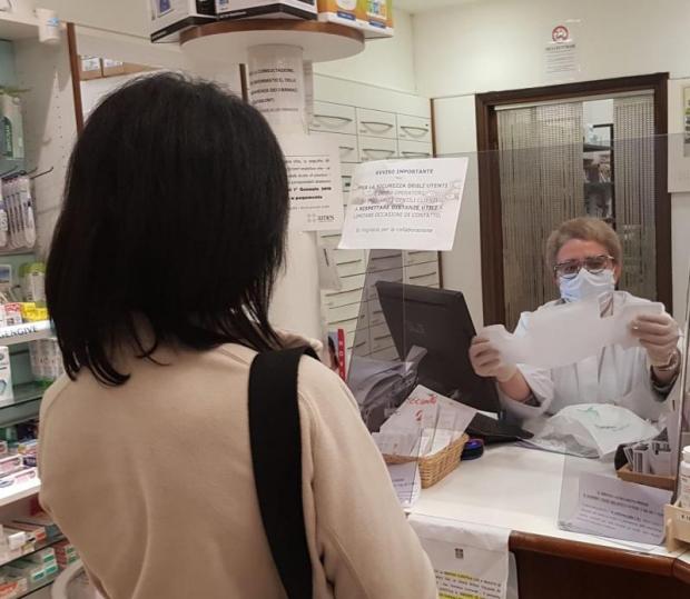 farmacista che consegna una mascherina