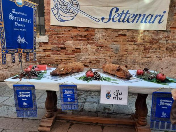 Tavola imbandita con due porchette intere e decorata con pigne e melograni