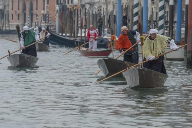 vogatori vestiti da befana gareggiano sul Canal Grande